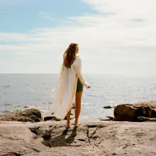woman standing on rocky beach