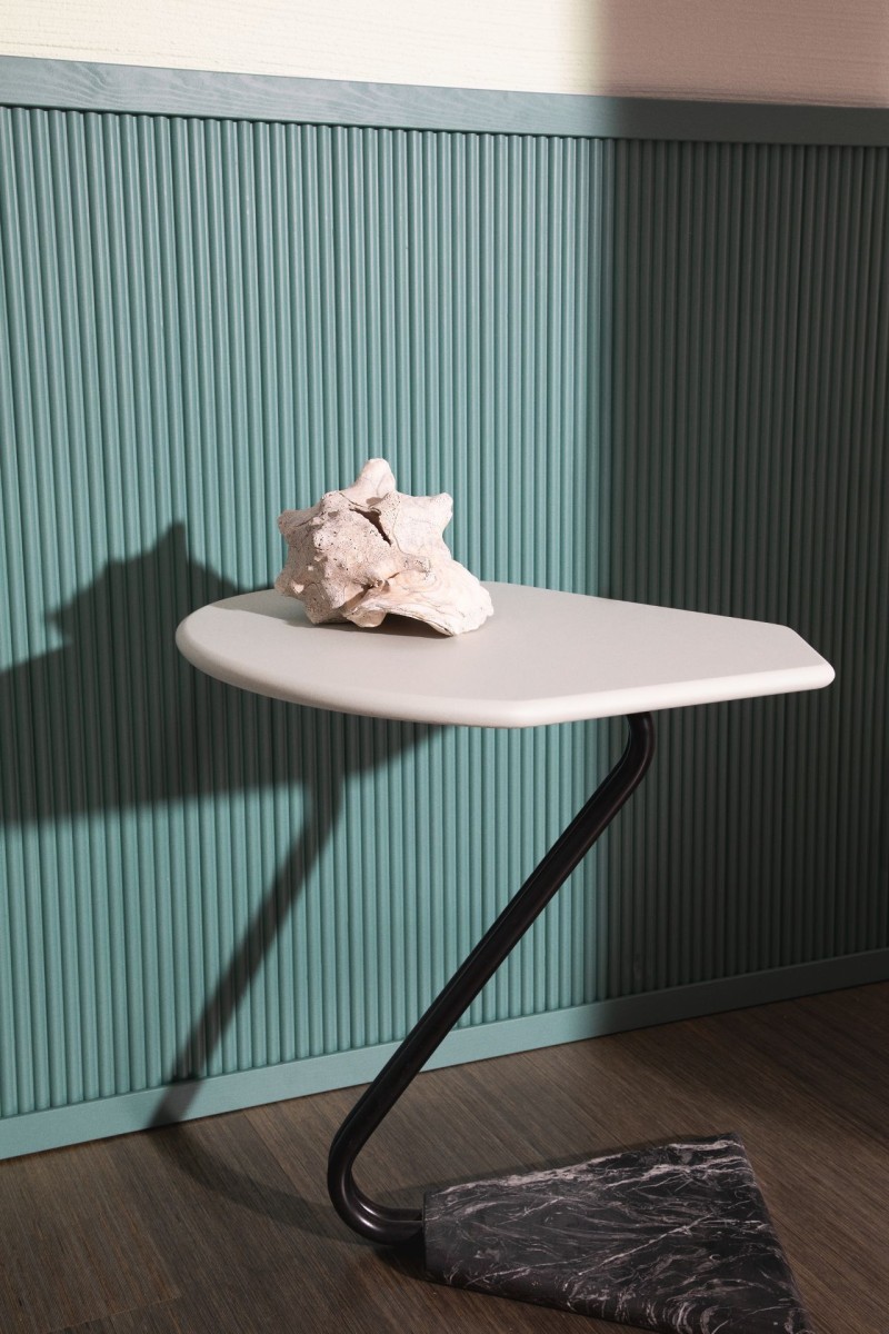 minimalist white side table in front of blue-green colour half panel wall 